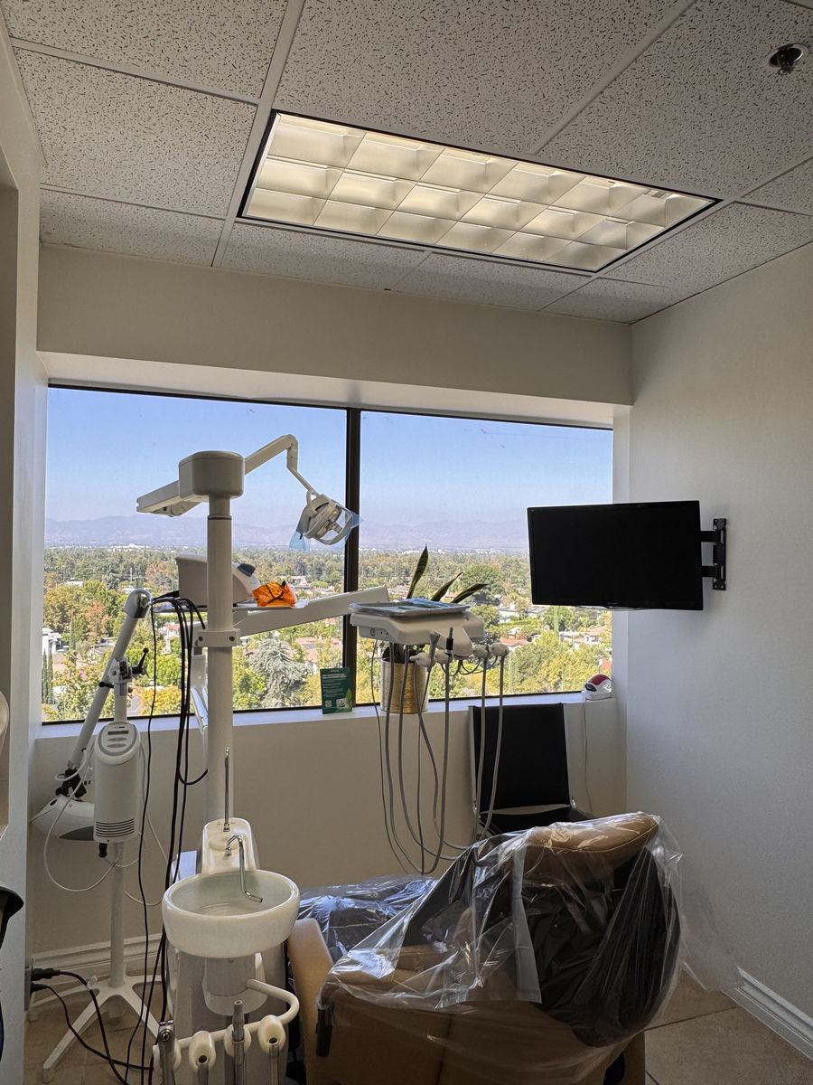 Private treatment room with a wall mounted monitor at Farzad Dental Encino