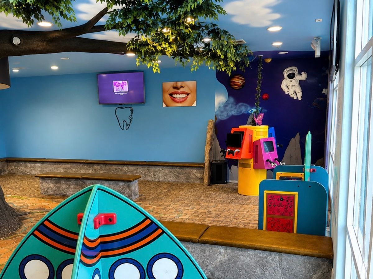 Space themed waiting area with game stations at Farzad Dental Palmdale
